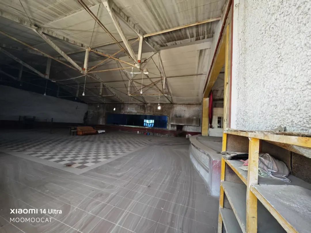 我把手机伸进破碎的窗户里，拍了一张内部照片，右边是舞台，左边观众席